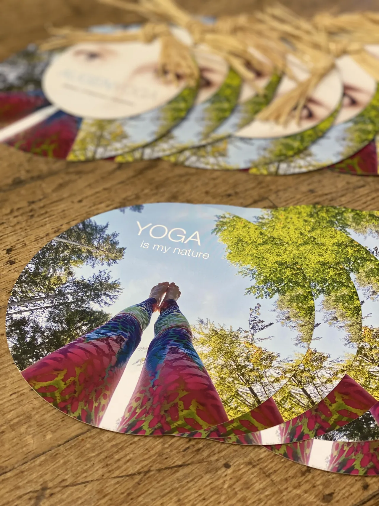 Runde Yogadina-Printkarten mit Waldmotiv auf einem Holztisch.