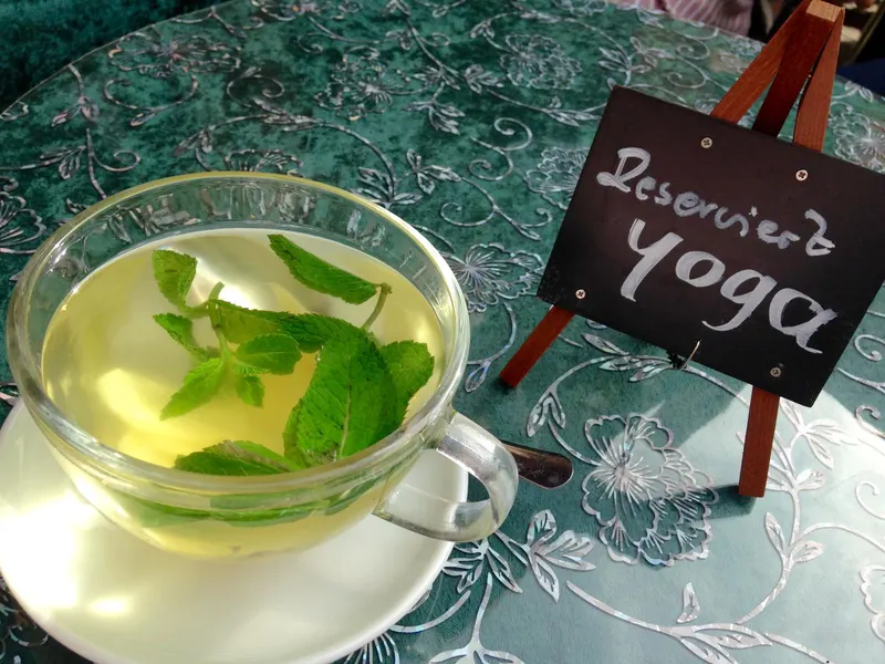 Eine Tasse Tee neben einem Schild mit der Aufschrift „Reserviert Yoga“.
